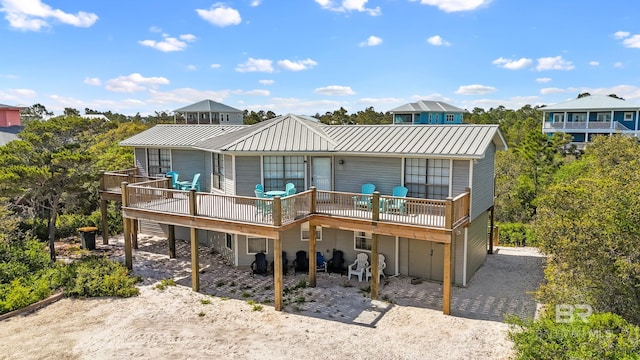 rear view of property featuring metal roof and a wooden deck