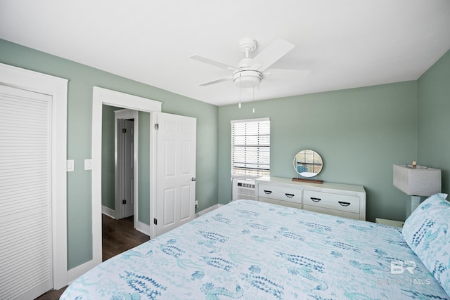 bedroom featuring dark wood-style floors, baseboards, ceiling fan, and cooling unit