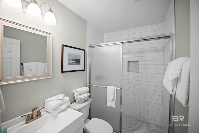 bathroom featuring a shower stall, toilet, and vanity
