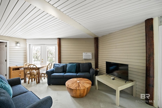 living area featuring wooden walls, french doors, and a wall mounted air conditioner