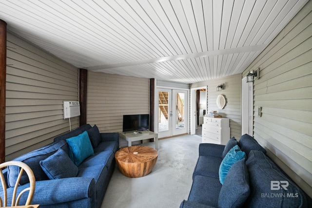 living area featuring wood walls and concrete flooring