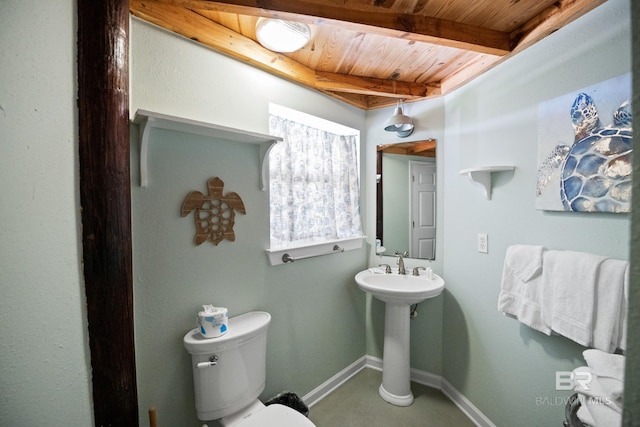 bathroom with wood ceiling, beamed ceiling, baseboards, toilet, and a sink