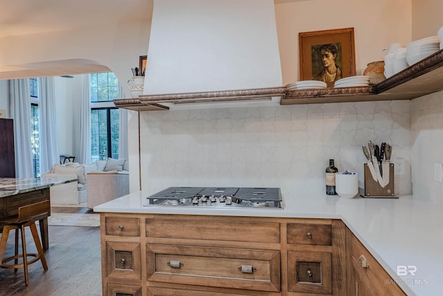 kitchen with backsplash, wood-type flooring, and stainless steel gas cooktop