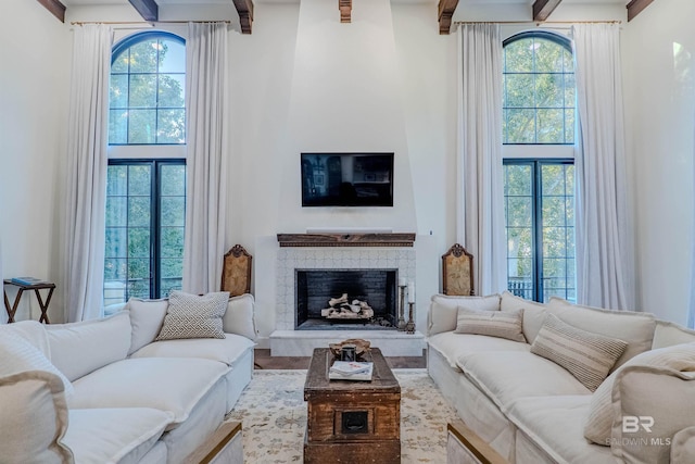 living room featuring a tiled fireplace and beam ceiling