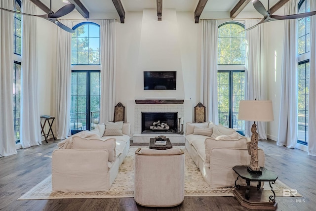 living room featuring ceiling fan, hardwood / wood-style floors, and a tile fireplace