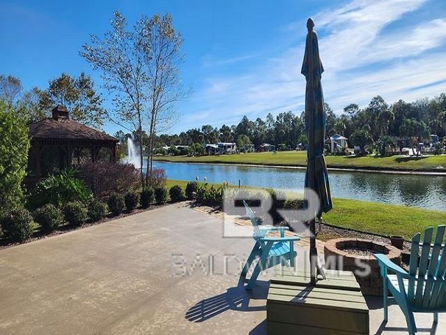 view of home's community with a patio, a water view, a gazebo, and a fire pit