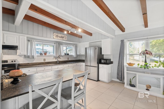 kitchen featuring appliances with stainless steel finishes, sink, light tile patterned floors, and white cabinets