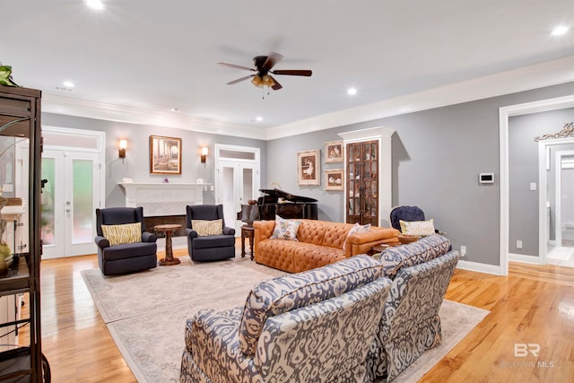 living room featuring ornamental molding, ceiling fan, light hardwood / wood-style flooring, and french doors