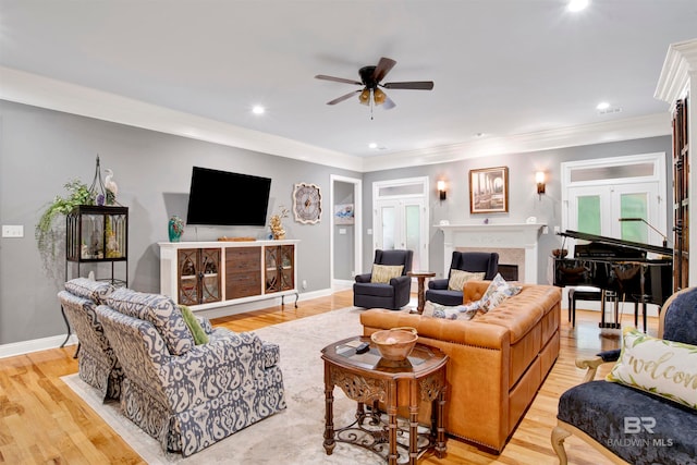 living room with ceiling fan, crown molding, and light hardwood / wood-style floors