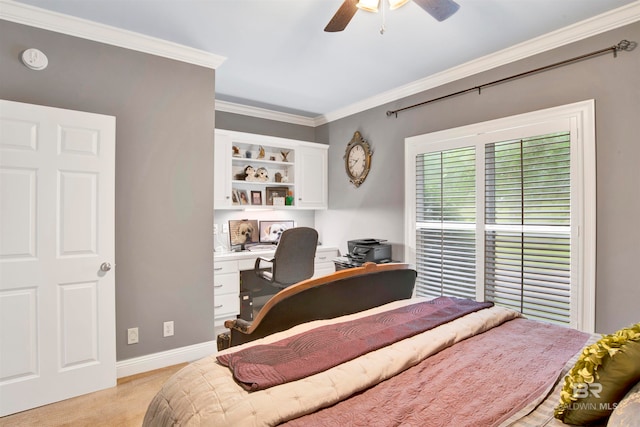 bedroom with ornamental molding, built in desk, ceiling fan, and light colored carpet