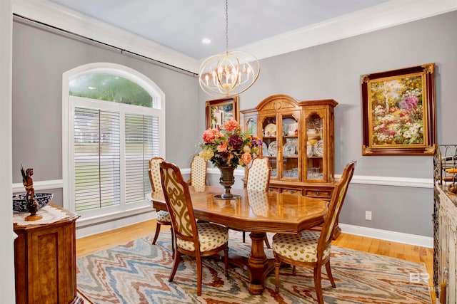 dining space with ornamental molding, light hardwood / wood-style flooring, and an inviting chandelier