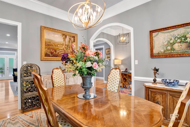 dining area featuring ornamental molding, light hardwood / wood-style floors, and french doors