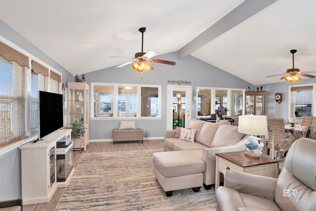 living room with ceiling fan, light wood-type flooring, and lofted ceiling with beams