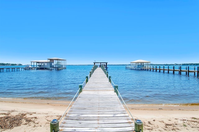 dock area featuring a water view and a beach view