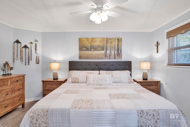 bedroom with ceiling fan, a textured ceiling, and light hardwood / wood-style flooring