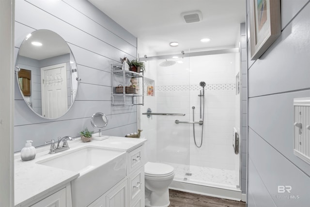 bathroom featuring vanity, toilet, hardwood / wood-style floors, and walk in shower