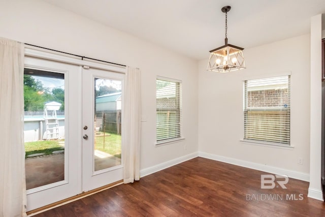 doorway to outside with dark wood-type flooring, an inviting chandelier, and french doors