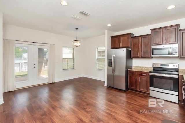 kitchen with appliances with stainless steel finishes, an inviting chandelier, french doors, dark hardwood / wood-style flooring, and hanging light fixtures