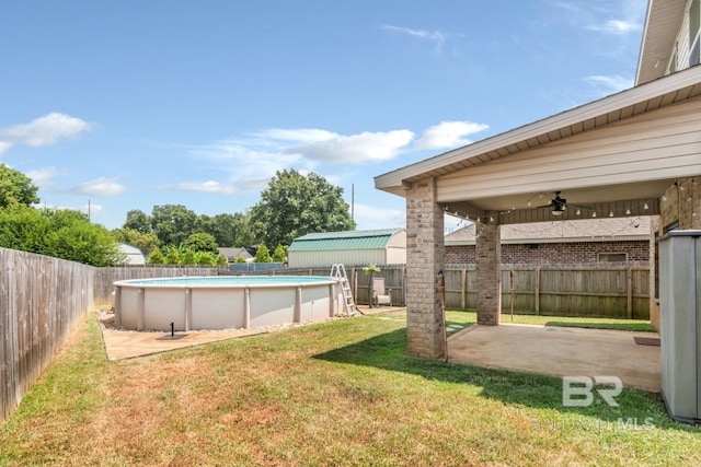 view of yard with ceiling fan and a fenced in pool