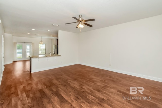 empty room featuring ceiling fan, sink, dark wood-type flooring, and french doors