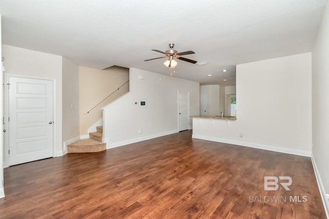 unfurnished living room with sink, ceiling fan, and wood-type flooring