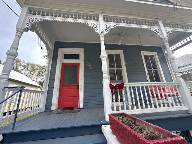 view of exterior entry featuring ceiling fan and a porch