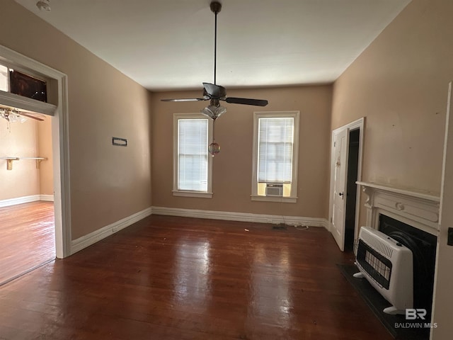 unfurnished living room with dark wood-type flooring, ceiling fan, and heating unit