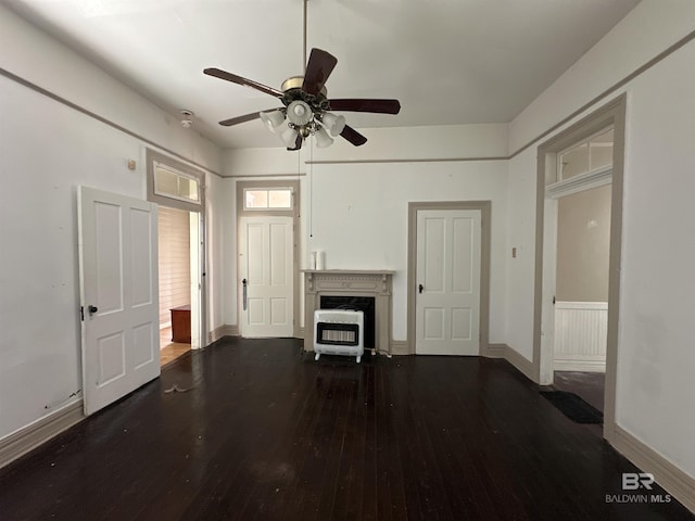 unfurnished living room featuring dark wood-type flooring, ceiling fan, a high end fireplace, and heating unit