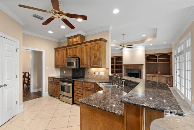 9529 Aspen Cir, Daphne, AL 36527 - kitchen with ceiling fan, stainless steel appliances, a sink, brown cabinetry, and a peninsula