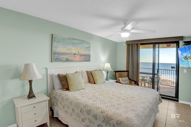 bedroom featuring ceiling fan, access to exterior, light tile patterned floors, and a water view