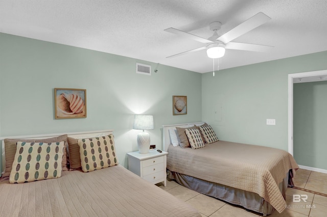 tiled bedroom featuring ceiling fan and a textured ceiling