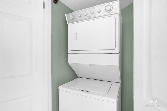 washroom with stacked washer / dryer and a textured ceiling