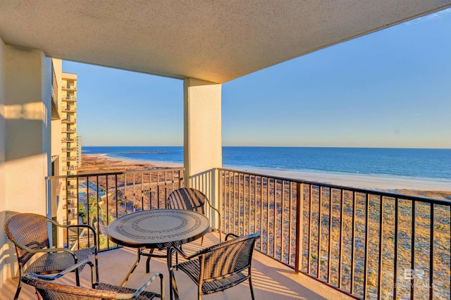 balcony featuring a water view and a view of the beach