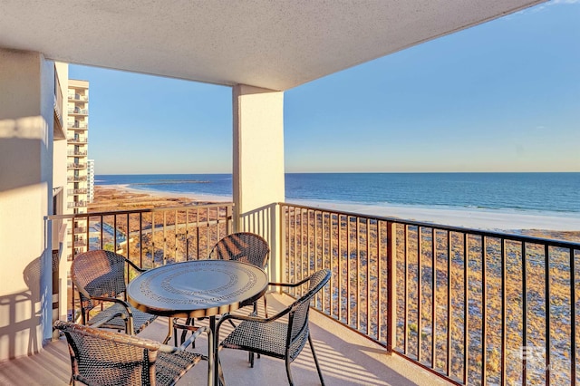 balcony featuring a water view and a view of the beach