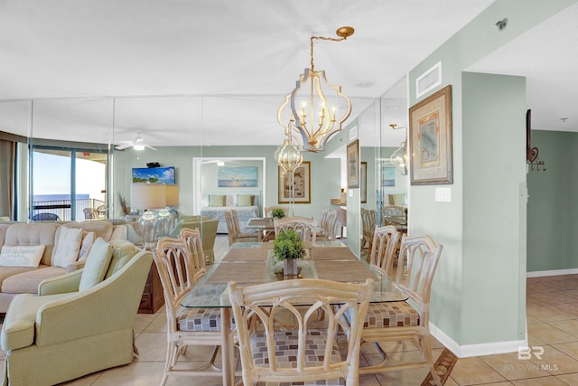 tiled dining area with ceiling fan with notable chandelier and a wall of windows