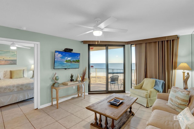 living room featuring ceiling fan, light tile patterned floors, and a wall of windows