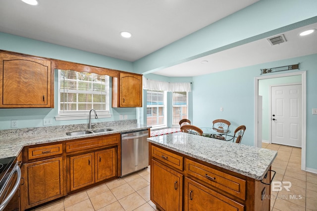 2553 Santa Rosa Dr, Lillian, AL 36549 - kitchen featuring stainless steel appliances, a sink, light tile patterned floors, brown cabinetry, and recessed lighting