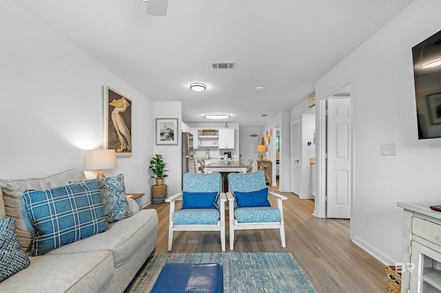 living room featuring ceiling fan and hardwood / wood-style floors