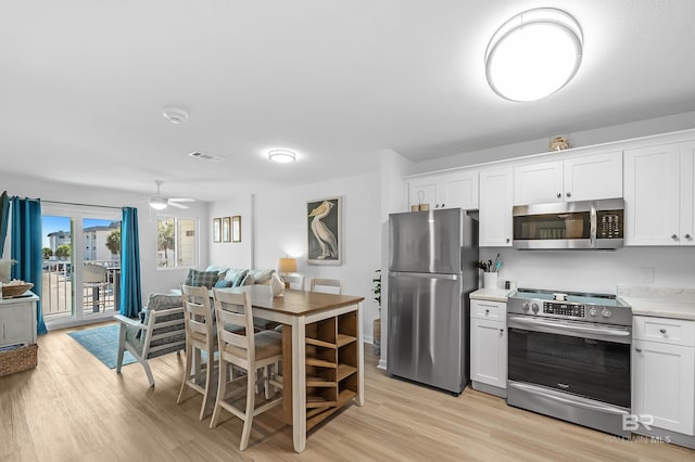 kitchen featuring light hardwood / wood-style flooring, stainless steel appliances, white cabinetry, and ceiling fan