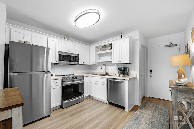 kitchen featuring light hardwood / wood-style flooring, stainless steel appliances, sink, and white cabinetry