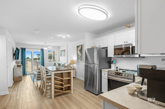 kitchen featuring light hardwood / wood-style flooring, white cabinets, ceiling fan, and appliances with stainless steel finishes