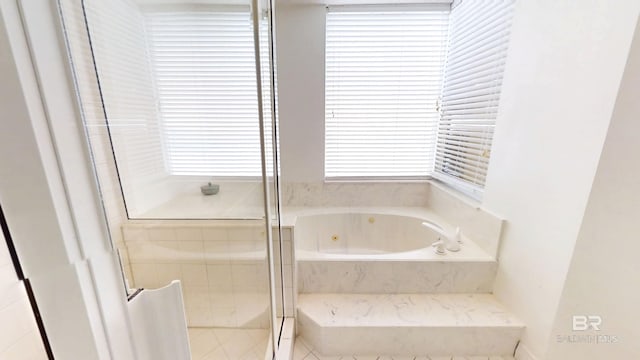 bathroom featuring shower with separate bathtub