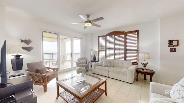 tiled living room with ceiling fan and a textured ceiling