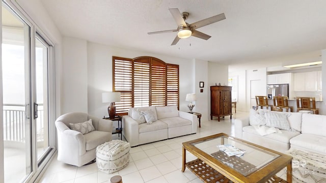 living room with a textured ceiling, ceiling fan, and light tile patterned flooring