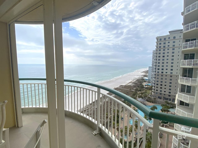 balcony featuring a water view and a beach view