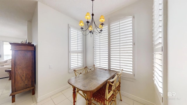 tiled dining room featuring a wealth of natural light and a chandelier
