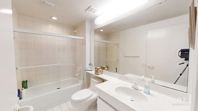 full bathroom with tile patterned floors, toilet, a textured ceiling, vanity, and tiled shower / bath combo