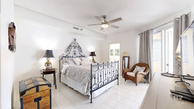 tiled bedroom featuring a textured ceiling and ceiling fan