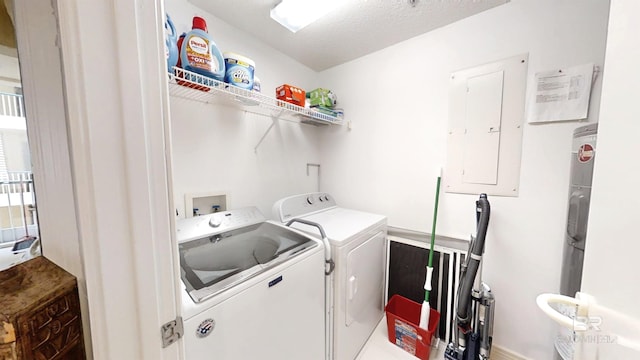 laundry area with washing machine and dryer, electric panel, and a textured ceiling