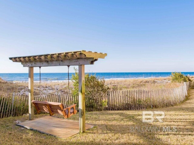 view of community featuring a view of the beach, a yard, and a water view